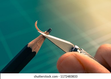 Macro picture hand sharpening blunt pencil and art knife green cutting mat  trying concept