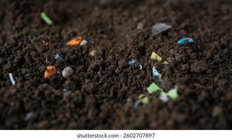 Micro contaminación de residuos plásticos en el campo agrícola. Fragmentos de microplásticos dentro del suelo en el jardín. El concepto de contaminación por plásticos y la agroindustria. Captura de macro de enfoque selectivo.