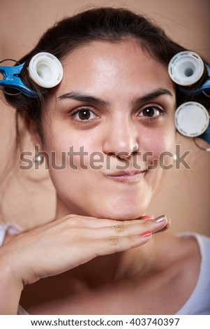 macro portrait of girl with curler with hand next to face