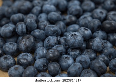 Macro seamless background texture of abundant fresh blue ripe blueberries scattered on a surface. Organic summer superfood harvest flat lay.