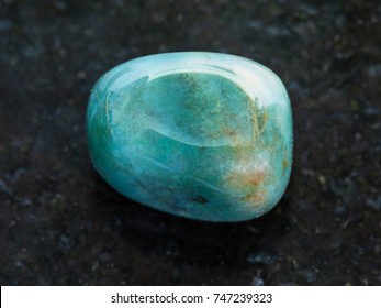 Macro Shooting Of Natural Mineral Rock Specimen - Tumbled Heliotrope Gem Stone On Dark Granite Background