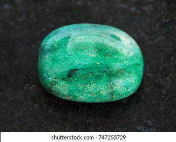 macro shooting of natural mineral rock specimen - polished green beryl gemstone on dark granite background - Shutterstock ID 747253729
