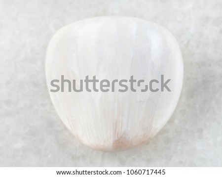 macro shooting of natural mineral rock specimen - polished Scolecite gemstone on white marble background from Pune region, India