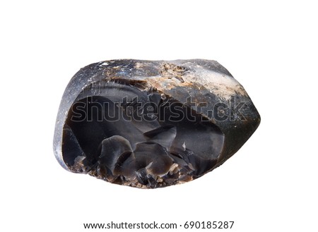 Macro shooting of rock specimen - natural black flint mineral isolated on white background. The texture of chipped black flint close-up. Traces of chips on the surface of black flint.