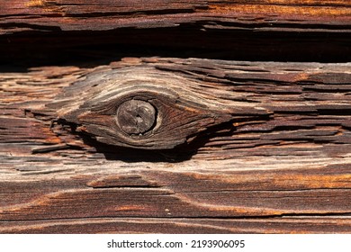 Macro Shot Of An Ancient Weathered Dark Brown Cracked Wood Beam Surface With Nice Rough Grain Texture.