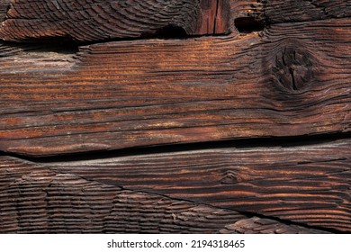 Macro Shot Of An Ancient Weathered Dark Brown Cracked Wood Beam Surface With Nice Rough Grain Texture.