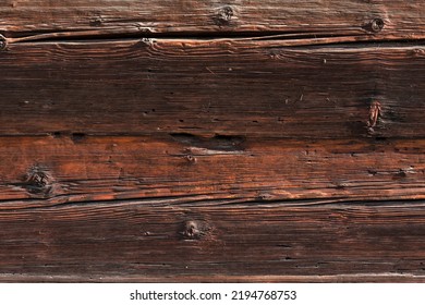 Macro Shot Of An Ancient Weathered Dark Brown Cracked Wood Beam Surface With Nice Rough Grain Texture.