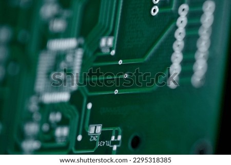 Macro shot of the back side of a circuit board. Close up of a printed green computer circuit board. Circuit board background