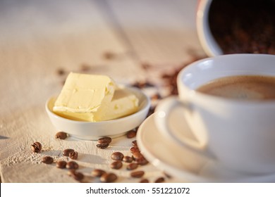 Macro shot of butter for coffee with beans on white table