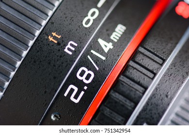 Macro shot of a camera lens focusing on camera lens information the aperture size f 2.8 and ens focal length is 14 mm.