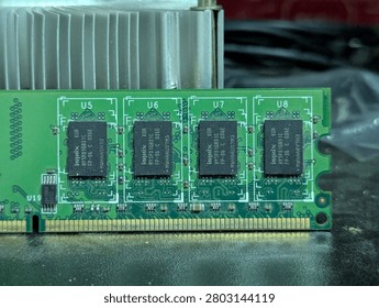 Macro shot of a computer RAM stick hardware component on a wooden table.
