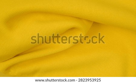 macro shot of a deep smooth bend of soft yellow textile with beautiful light and shadow