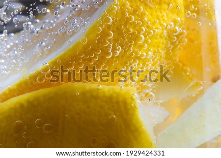 macro shot of a detail of detox water containing ginger and lemon with bubbles indicating freshness of the beverage
