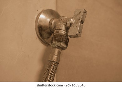 Macro shot detailing an outdated or neglected plumbing fixture. The metal surface is visibly tarnished with green-blue oxidation and mineral deposits from hard water. Represents plumbing
