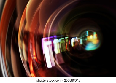 Macro shot of front element of a camera lens with beautiful color lights reflections