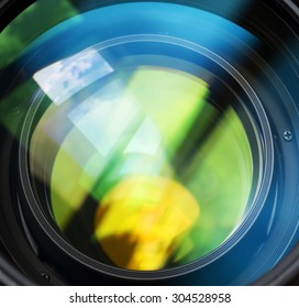 Macro shot of front element of a lens with beautiful color lights reflections