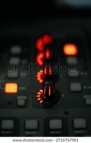 Macro shot of glowing red knobs and buttons on a professional sound mixing board, perfect for music production and studio themes.
