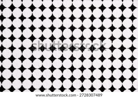 Macro shot of a halftone dot grid pattern printed in black ink on white paper. Circular dots form a clean, repeating geometric layout.