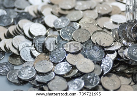 Macro shot of a large quantity of coins stacked in chaos
