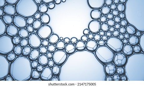 Macro shot of many clear different sized bubbles connected tightly each to other creating a grid on cyan background | Abstract beauty product ingredient shot - Shutterstock ID 2147175005