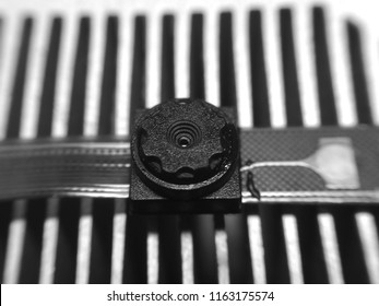 A macro shot of a mobile camera module in black and white.