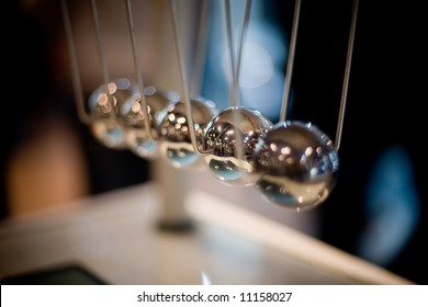 Macro shot of newton's cradle with shallow depth of field (only second ball is in focus)