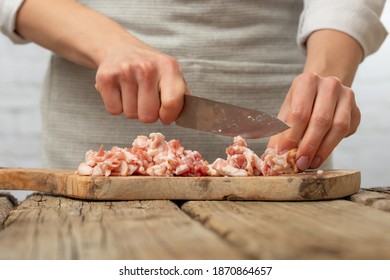 Macro Shot Of Professional Chef Cuts With Knife Bacon On Wooden Chopped Board For Cooking Pasta Alla Carbonara. Preparing Traditional Italian Dish On White Background. Cooking Process Concept.