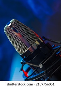 Macro Shot. Professional Microphone On A Blue Background. Music, Singing, Conversational Genre, Radio, Conference, Holiday, Karaoke. There Are No People In The Photo. Color Image.