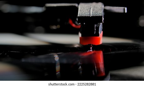 Macro Shot Of Retro Turntable With Red Tonearm Playbacking Melody From A Record. Stylus Of Gramophone With Needle Is Touching Black Vinyl Record. Old Music Player To Play Music. Concept Of Nostalgia.