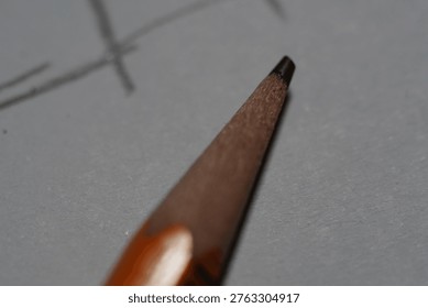 Macro shot of a sharpened pencil tip on paper.