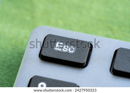 Macro shot showcasing of an Esc key of a modern keyboard, object detail, extreme closeup macro, nobody. Escape character button, escaping, closing an app, cancelling simple abstract concept, no people