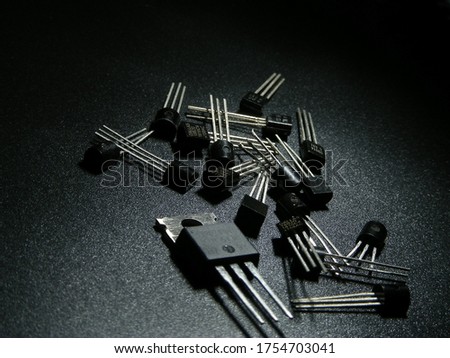 Macro shot of silicon power transistors on a black surface.
