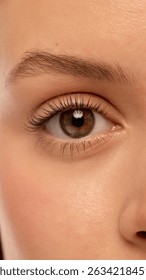 Macro shot of single eye with sharp lashes, natural brown iris, smooth eyelid and perfectly shaped brow. Female model with smooth healthy skin. Concept of natural beauty, eye care, cosmetic products