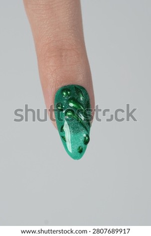 Macro shot of single fingernail featuring volumetric chrome green waves and beads