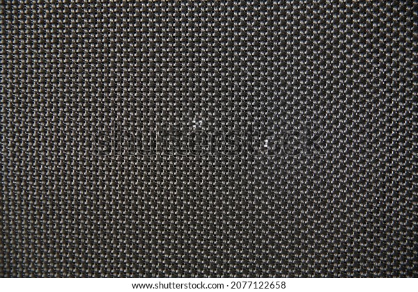 Macro shot of speaker\
grille. Vintage effect. Close up shot of a round speaker. Acoustic\
broadband speaker. Luxury car stereo system speaker. Holes in a\
metal lattice.