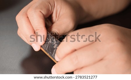 Macro shot of a technician testing the durability of a flexible electronic circuit board.