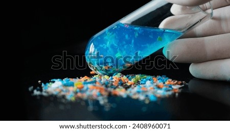 Macro shot of a test tube full of micro plastics collected from the beach. Concept of water pollution and industrial waste management.