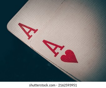 Macro shot texture of playing cards. A pair of aces on a black background. Ace of hearts and ace of diamonds. Nuts hand a pair of aces to win. Close-up image a pair of aces.