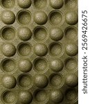 A macro shot of a textured green surface with a repetitive pattern of circular bumps, captured with a Canon EOS R5 camera in natural light, highlighting the tactile nature of the material.