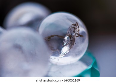 Macro shot of transparent crystal balls with orange ornaments standing on glass pad with sun reflections in it. Fortune telling. Love, money, luck, success - Shutterstock ID 690051169