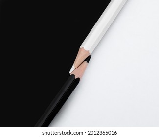 Macro shot of two black and white colored pencils with the tips touching on a matching background with opposite colors. Top down view flat lay. Concept of contrast or opposites attract - Powered by Shutterstock