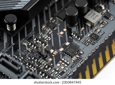 Macro shot of VRM MOSFETs and Capacitor (Voltage Regulator Module) on a modern motherboard. Mosfets, Solid-state capacitors, Chokes, Field-effect transistors, VRM. Technological background.