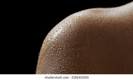 Macro Shot Of Wet Shoulder Skin Of Young African American Female Model On Black Background | Skin Texture Shot For Skin Hydration Concept