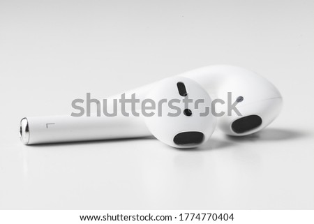 Macro shot of the white wireless in ear headphones on the white background