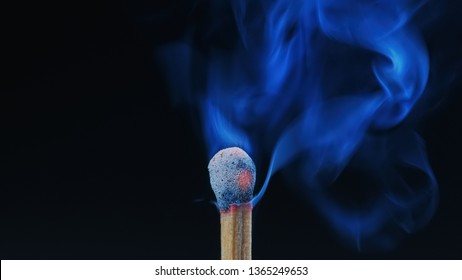 Macro shot of wooden matchstck smoking, just having  extinguished its flame while its red head is still glowing with embers.