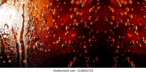 Macro Soft Drink Texture,Close Up View Of Ice Cubes In Dark Cola Background. Textures Of Sweet Summer Cold Drinks With Foam And Macro Bubbles On Fizzing Glass Wall. Or Float To The Top Of The Surface