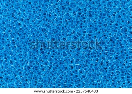 Macro spongy texture background. Very close-up view of blue filtration sponge.