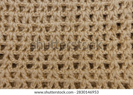 Macro texture of beige openwork crocheted fabric, Warm winter apparel fabric background