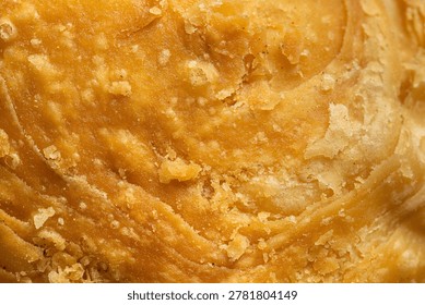 Macro texture of crispy layered puff pastry dough background,Extreme close-up texture of golden brown curry puff pastry, showing detailed crispy layers and crunchy surface background.