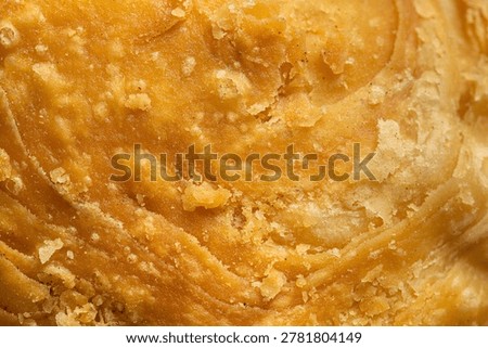 Macro texture of crispy layered puff pastry dough background,Extreme close-up texture of golden brown curry puff pastry, showing detailed crispy layers and crunchy surface background.